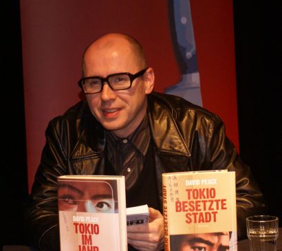 Portrait de David Peace devant ses deux livres.