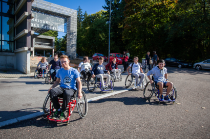 Des étudiants en fauteuil roulant devant la Maison des étudiants sur le campus de la Bouloie