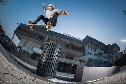 Jeune skateur en pleine acrobatie au-dessus d'une poubelle