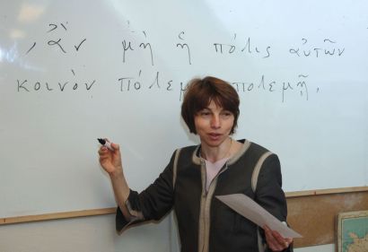 Marie Rose Guelfucci devant un tableau avec du texte en grec ancien