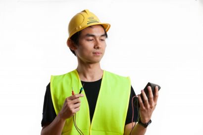 Un étudiant avec un casque de chantier et un gilet jaune fluo
