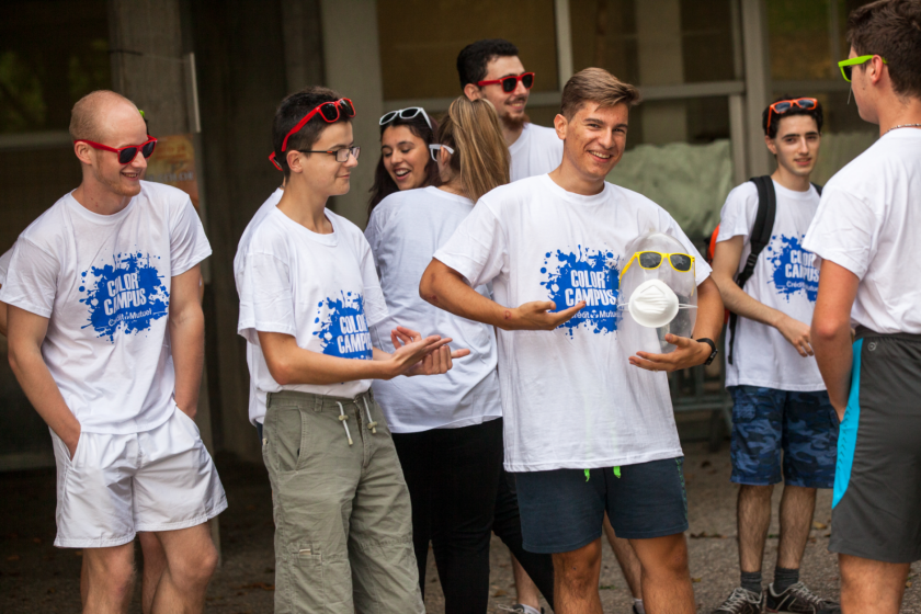 Des étudiants tous équipés du même tee shirt blanc montrent leur tee-shirt