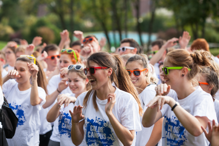 Un groupe d'étudiantes très souriantes avec lunettes de soleil colorées et toutes le même tee shirt