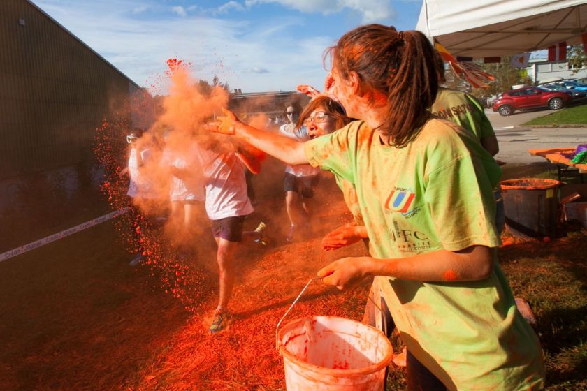 Une jeune fille jette de la poudre rouge sur les coureurs.