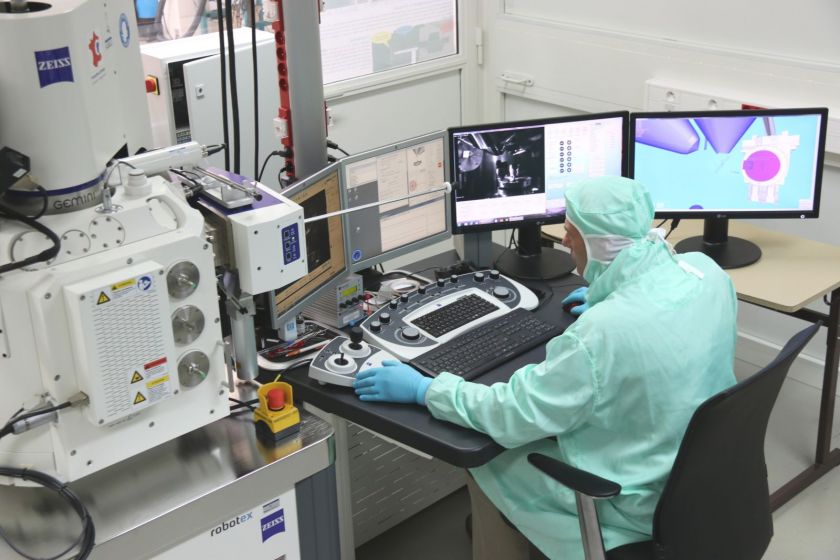 Jean-Yves Rauch devant des écrans d'ordinateur et des appareils de microfabrication.
