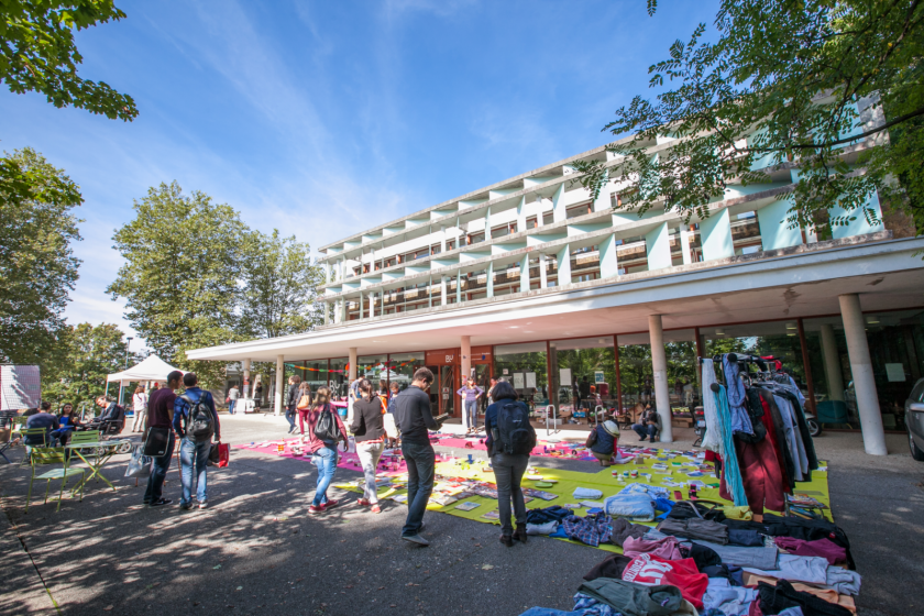 Vue large du parvis de la bibliothèque universitaire droit sur laquelle a été installée une sorte de brocante.