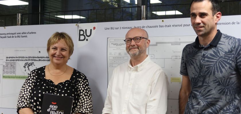 Macha Woronof, Sébastien Coudry et François Calais devant un des panneaux d'exposition sur les 20 ans de la BU Santé