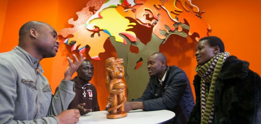 Quatre étudiants africains en train de discuter autour d'une table.