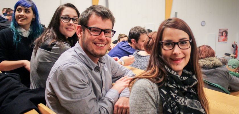 Un groupe d'étudiants souriants dans un amphi