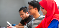 Deux étudiants et une étudiante malaisienne souriants.