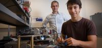 Bodgan Penkovsky et Laurent Larger devant un dispositif expérimental optique.