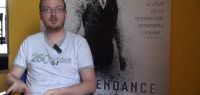 Julien Bernard devant une affiche de cinéma
