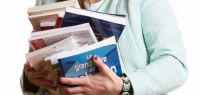 Une étudiante avec une pile de livres dans les bras