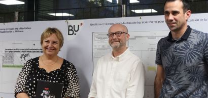 Macha Woronof, Sébastien Coudry et François Calais devant un des panneaux d'exposition sur les 20 ans de la BU Santé