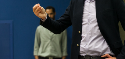 Un étudiant en costume parle devant un public