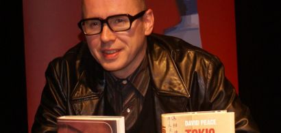 Portrait de David Peace devant ses deux livres.