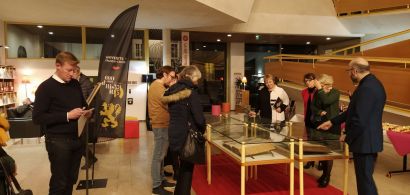 publics entourant des vitrines de documents anciens exposés à la BU Belfort dans le cadre des 600 ans de l'université