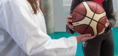 Quelqu'un en blouse tend un ballon à quelqu'un d'autre