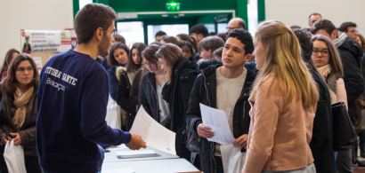 Un tuteur renseigne des étudiants dans la foule des journées portes ouvertes dans le hall de l'UFR Santé.