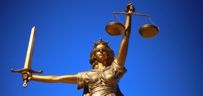 Un globe et une statuette de femme les yeux bandés tenant une balance