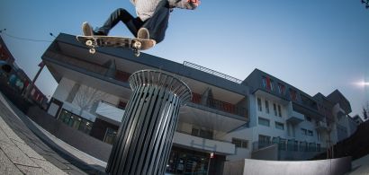 Jeune skateur en pleine acrobatie au-dessus d'une poubelle