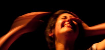 Visage d'une femme souriante floue, elle a une main sur une tête et l'autre qui va se poser dessus.