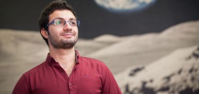 Photo du doctorant avec un fond représentant l'espace et une planète derrière lui