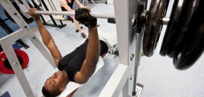 Un étudiant soulève des poids dans la salle de musculation
