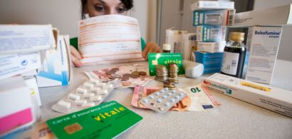Une jeune femme qui se cache derrière des médicaments et des feuilles de soins