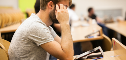 Un étudiant devant sa tablette dans un amphi