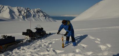 Un homme en train de faire un carottage de glace 