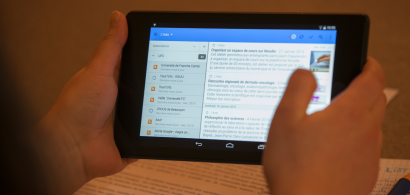 Deux mains tenant une tablette numérique