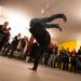 Un jeune homme fait une démonstration de hip hop devant un public.