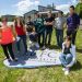 Un groupe d'étudiant et leurs enseignants posent devant l'aéroglisseur.