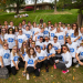 Un groupe d'étudiants qui portent tous le même tee shirt et des lunettes de soleil colorées.