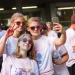 Quatre étudiantes couvertes de poudre colorée font un selfie.