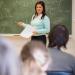 Céline Bourgeois en train de donner un cours à sa classe, elle se trouve devant son tableau.