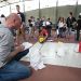 Un homme prend des notes à côté des pistes où il y a plusieurs robots.