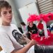 Un jeune garçon tient un robot a plumes.