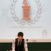 Un étudiant en costume sur l'estrade ouvre le concours.