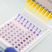 Une série de pipettes remplies d'un liquide violet. 