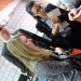 Deux étudiantes et un étudiant en train de regarder quelque chose.