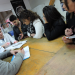 Un groupe d'étudiants autour d'une table examine une brochure sur les montres.