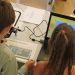 Deux enfants paramètrent un robot