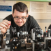John Dudley en train de manipuler un banc optique