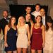 Des étudiants posent en tenue de gala sur un escalier.