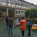 Plusieurs personnes de dos devant des ruches devant les bâtiments de l'IUT