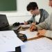 Deux étudiants au travail. Au premier plan, un dessin de canoé.