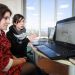 Une étudiante et une enseignante devant un ordinateur. L'étudiante présente son projet.