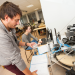 Un étudiant et une étudiante devant une machine d'encapsulage de bocaux